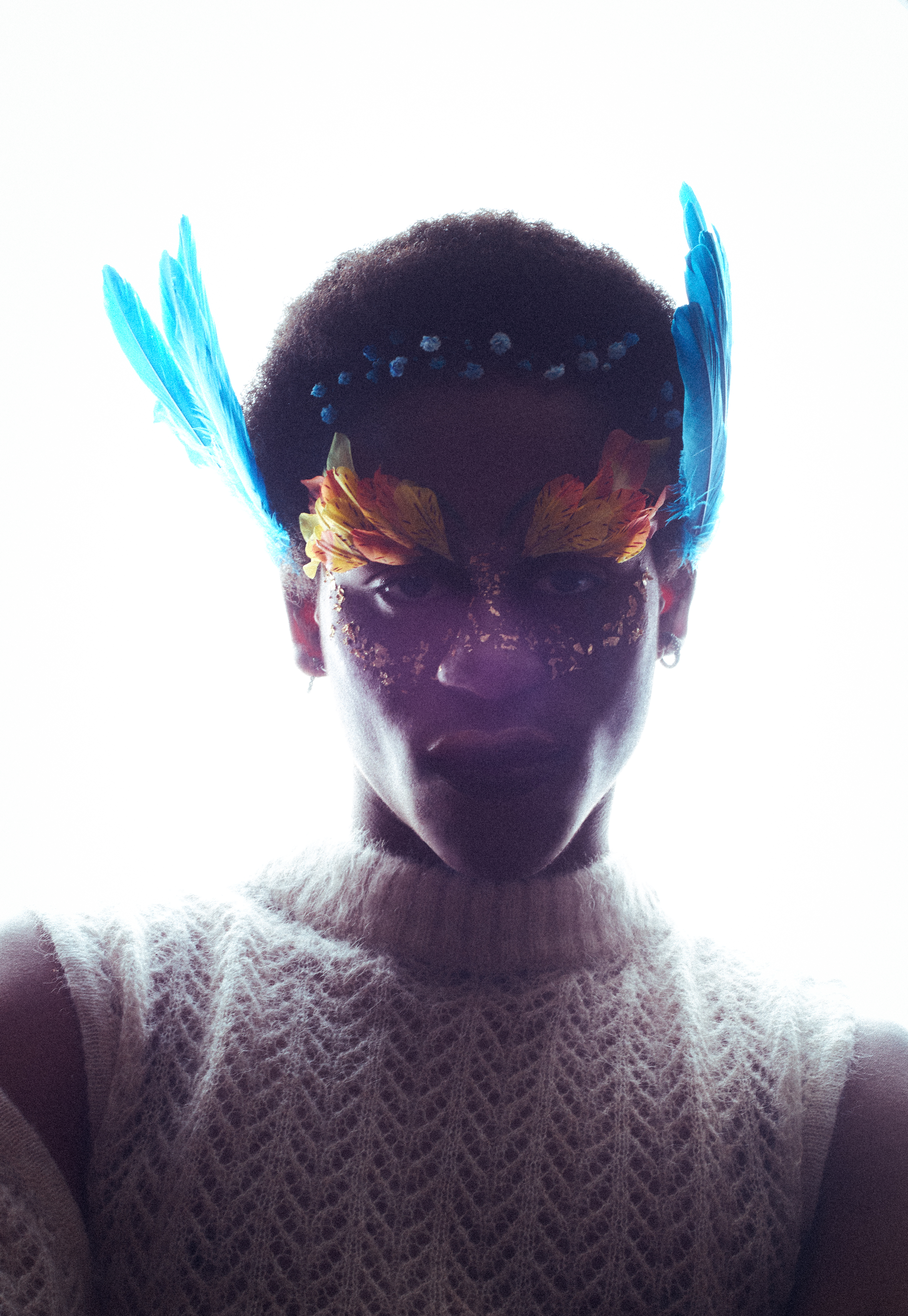 Retrato con tocado floral y plumas azules