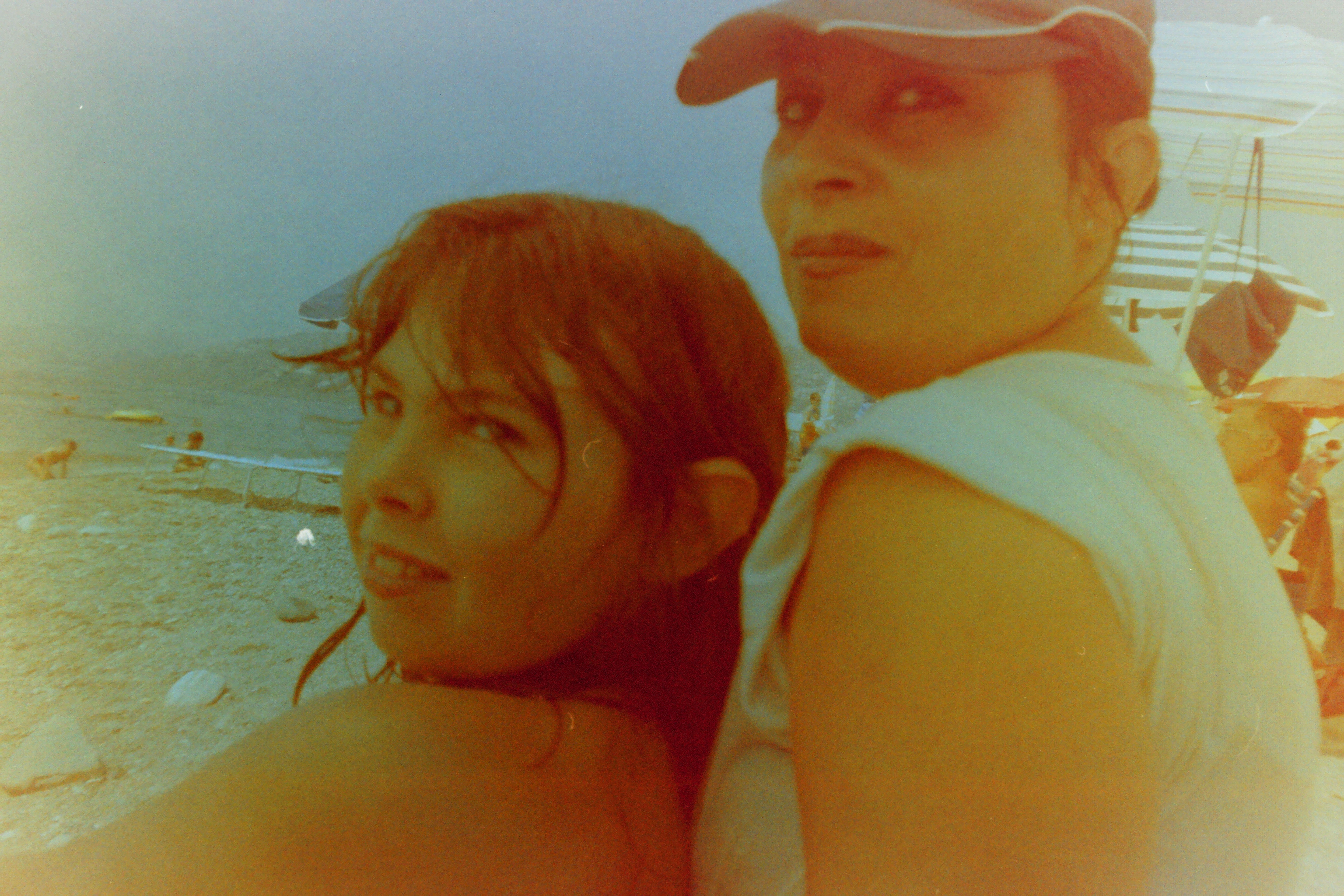 Dos personas de espaldas en una playa fotografiadas en un carrete caducado